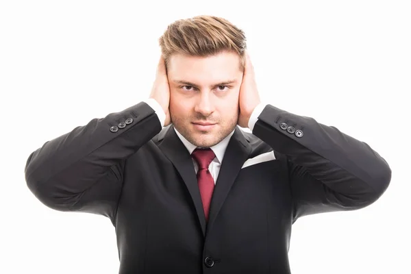 Красивый бизнесмен прикрывает уши, как глухой жест — стоковое фото