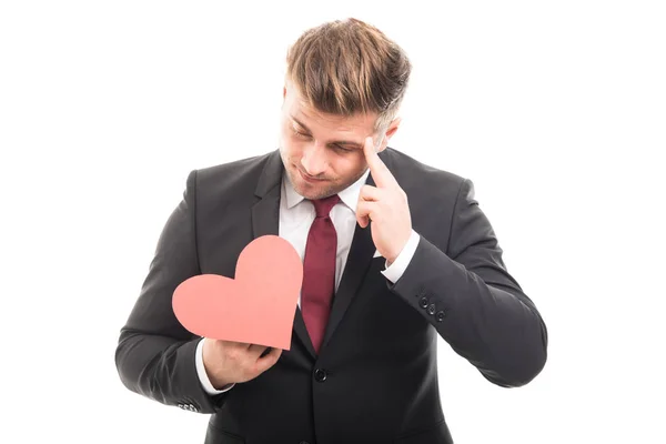 Junger Manager denkt und hält rotes Herz in Form — Stockfoto