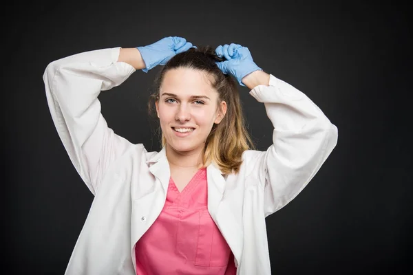 Młoda lekarka portret organizowanie jej włosy — Zdjęcie stockowe