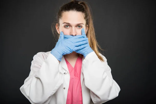 Jovem médico retrato segurando cobrindo a boca como conceito mudo — Fotografia de Stock