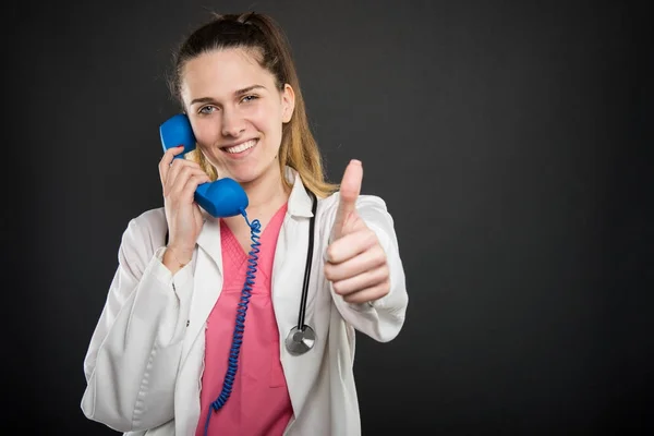 Retrato médico joven hablando por teléfono mostrando como — Foto de Stock