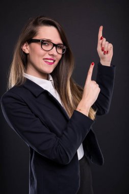 Genç iş kadını koyu arka plan işaret