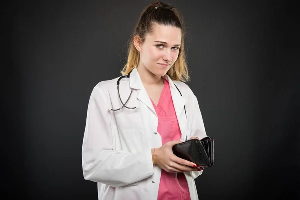 Mujer joven médico sosteniendo cartera buscando preocupado — Foto de Stock