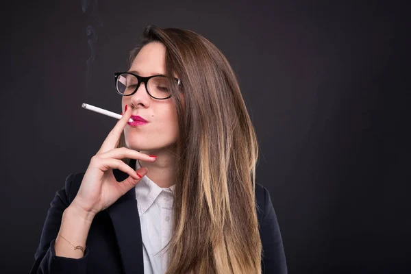 Elegant manager girl wearing glasses and smoking cigarette — Stock Photo, Image