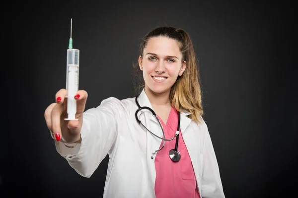 Селективный фокус женщины-врача показывает большой шприц — стоковое фото