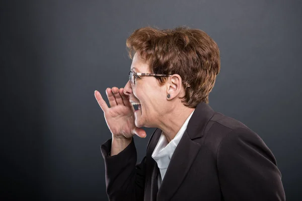 Вид сбоку на бизнес старшая леди, делающая кричащий жест — стоковое фото