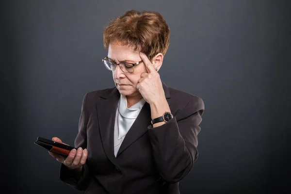 Empresa señora mayor pensando en sostener el teléfono inteligente —  Fotos de Stock