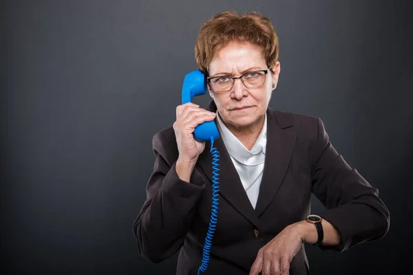 Business Senior Dame mit blauem Telefonhörer macht la — Stockfoto