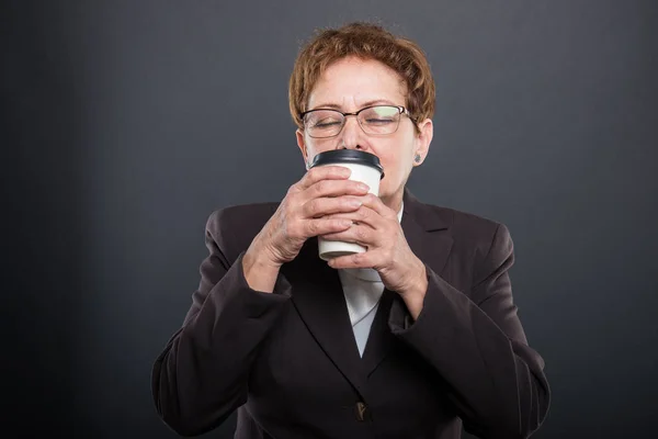 コーヒーのテイクアウト カップを楽しんでいるシニア女性のビジネス — ストック写真