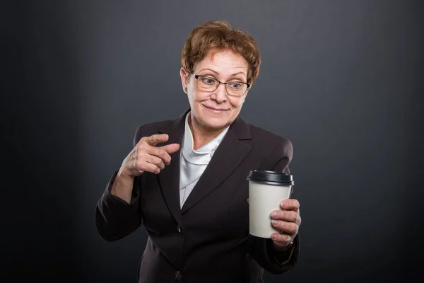 テイクアウト コーヒーを指していると笑顔のビジネス シニア女性 — ストック写真