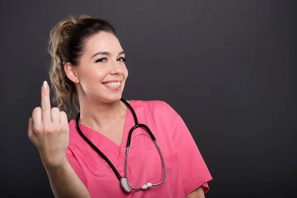 Retrato de atractiva doctora mostrando gesto obsceno — Foto de Stock