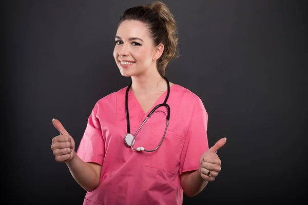 Retrato de atractiva doctora mostrando doble gesto —  Fotos de Stock