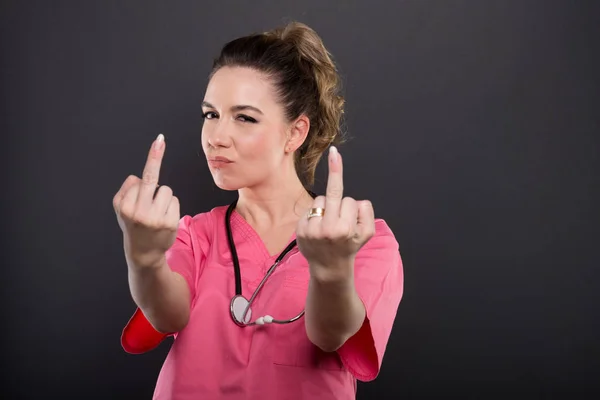 Portrait of attractive lady doctor showing double obscene gestur
