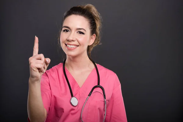 Πορτρέτο του ελκυστική γυναίκα γιατρός δείχνει αριθμό μία χειρονομία — Φωτογραφία Αρχείου