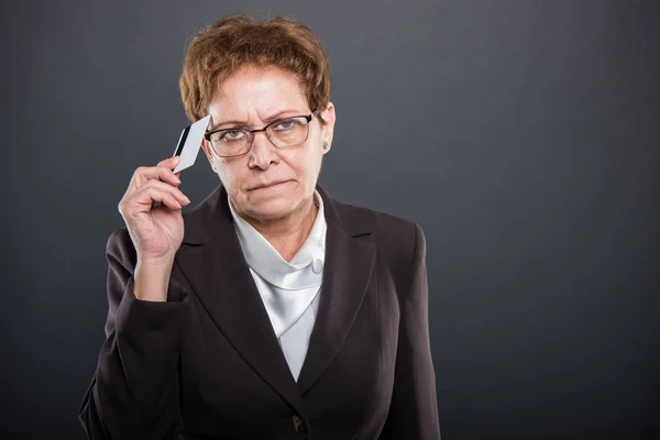 Seniorin macht Denkgeste mit Karte — Stockfoto