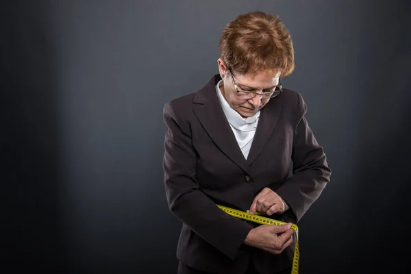 Hosté starší dáma sama měřící páskou — Stock fotografie