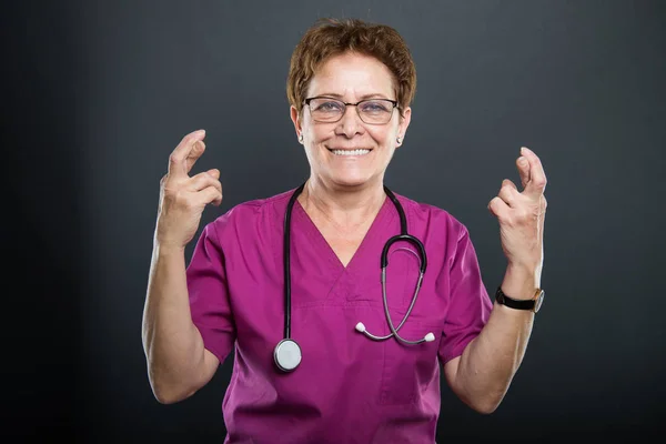 Portret van senior dame arts tonen dubbele vingers gekruist — Stockfoto