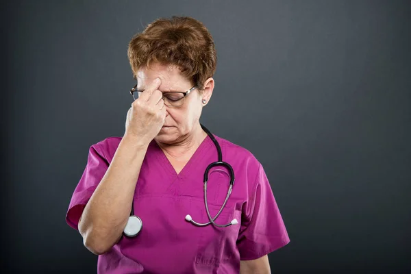 Porträtt av äldre dam läkare håller huvud som att ha smärta — Stockfoto