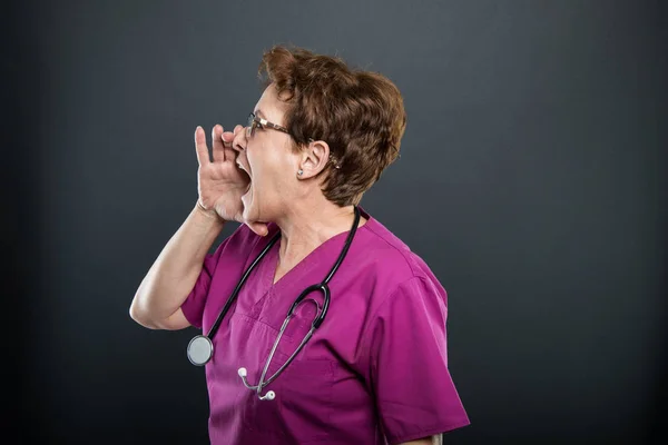Side view of senior lady doctor screaming — Stock Photo, Image