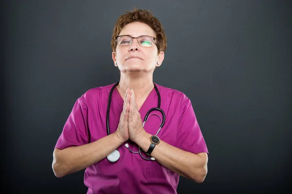 Portrait of senior lady making prayer gesture