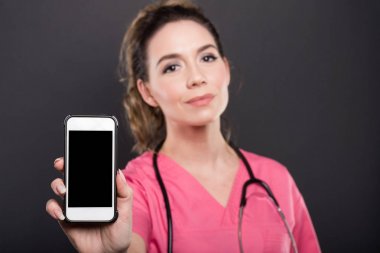 Bir kadın doktor siyah ekran smartphone tutan seçici odak