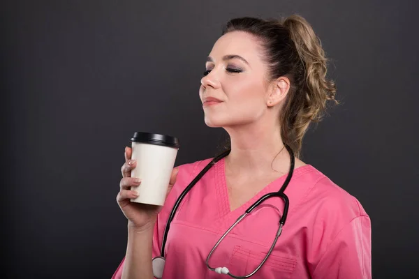 Paket servisi olan restoran kahve tutan güzel genç doktor yan görünüm — Stok fotoğraf