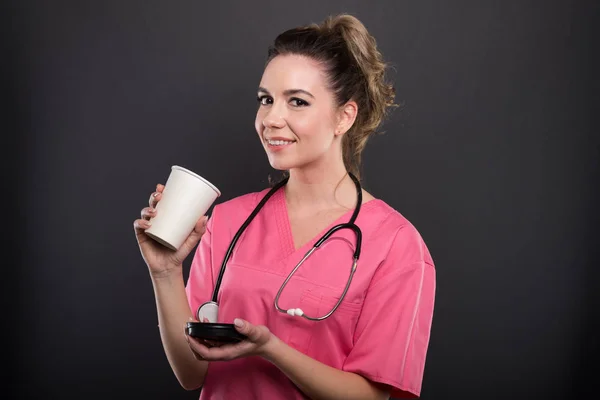 Portrait of beautiful young doctor drinking takeaway coffee — Stock Photo, Image