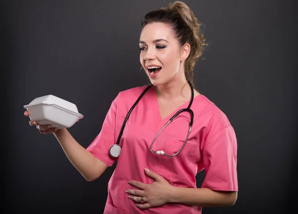 Portrait of beautiful young doctor holding lunch box — Stock Photo, Image