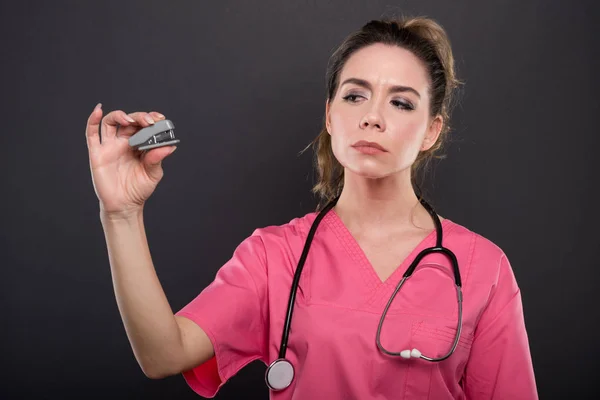 Retrato de una atractiva doctora sosteniendo una pequeña grapadora — Foto de Stock