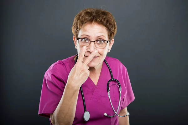 Portrait of senior lady doctor gesturing look into my eyes