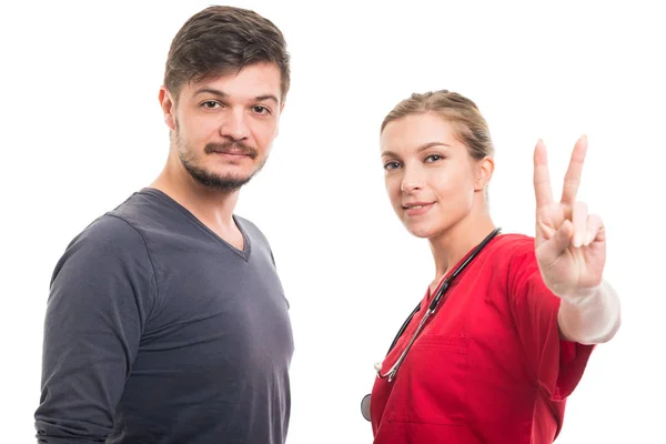 Male patient with female doctor showing peace gestur — Stock Photo, Image