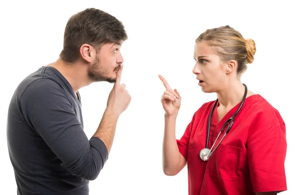 Male patient showing silence gesture to female docto — Stock Photo, Image
