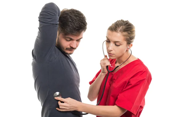 Médico feminino consultando paciente masculino com estetoscop — Fotografia de Stock