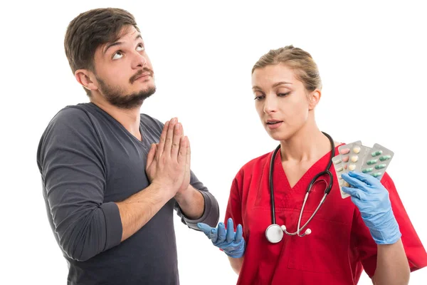 Mannelijke patiënt, bidden en vrouwelijke arts bedrijf blister — Stockfoto