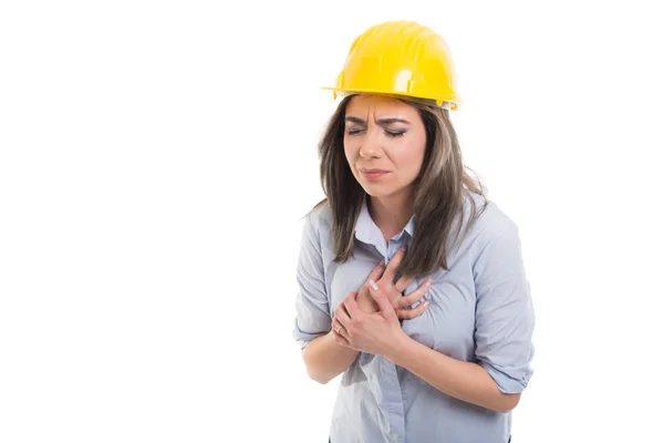 Retrato de construtora feminina segurando seu peito como hurtin — Fotografia de Stock