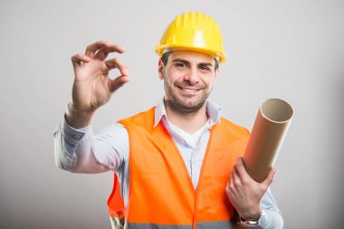 Tamam gestu yapma planları tutan genç mimar portresi