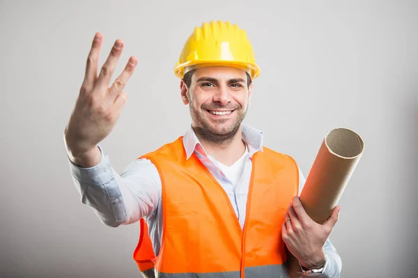 Portrait of young architect holding blueprints shows number th — Stok Foto