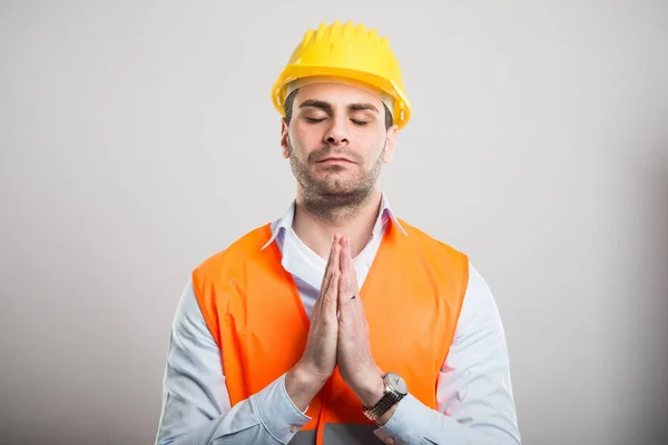 Retrato de un joven arquitecto cogido de la mano como orando — Foto de Stock