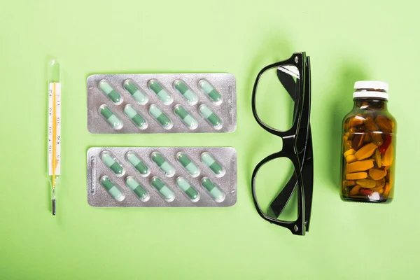Blíster de tabletas gafas termómetro y frasco de píldora —  Fotos de Stock