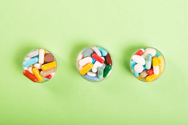 Three cups of colorful pills and tablet — Stock Photo, Image