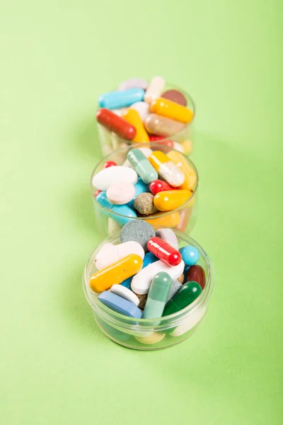 Три чашки разноцветных таблеток и таблетки — стоковое фото