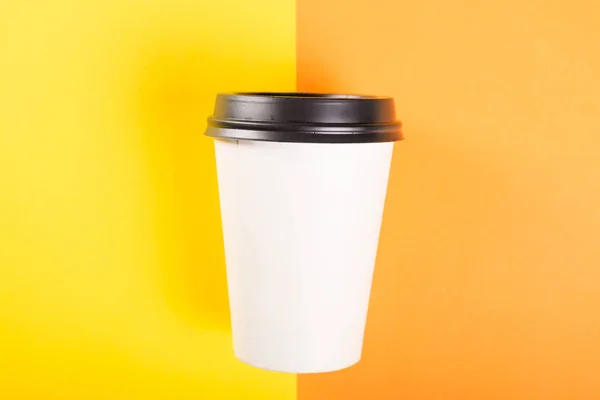 Чашка кофе на вынос на оранжевой и желтой спинке — стоковое фото