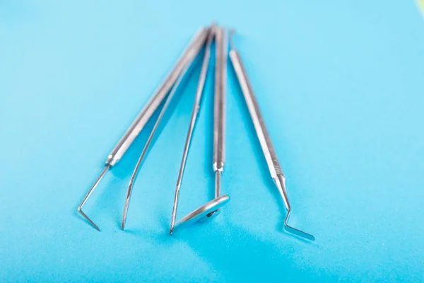 Set di strumenti di odontoiatria focus selettivo su backgroun blu — Foto Stock