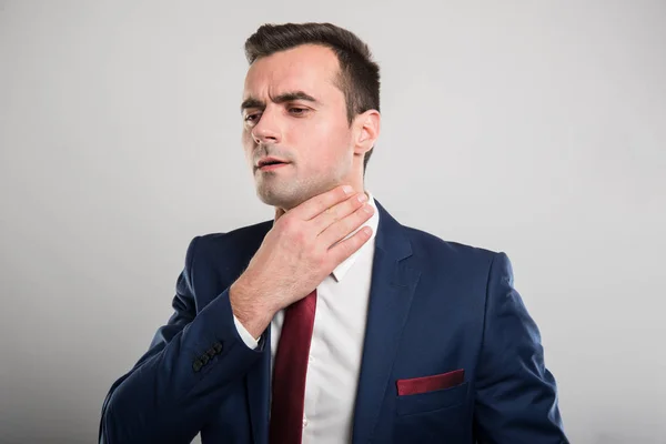 Atractivo hombre de negocios sosteniendo la garganta como herido — Foto de Stock