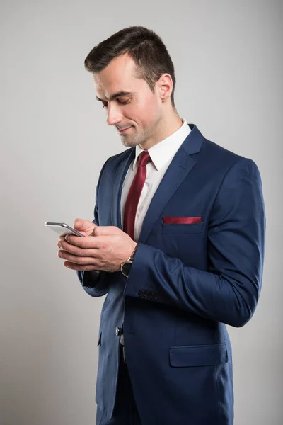 Homem de negócios atraente mensagens de texto no smartphone — Fotografia de Stock