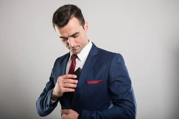 Attractive business man putting out wallet — Stock Photo, Image