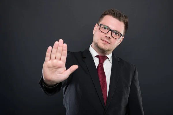 Retrato del hombre de negocios con traje negro mostrando gesto de stop — Foto de Stock