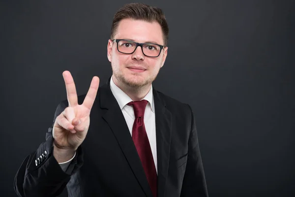 Retrato del hombre de negocios con traje negro mostrando el número tw — Foto de Stock