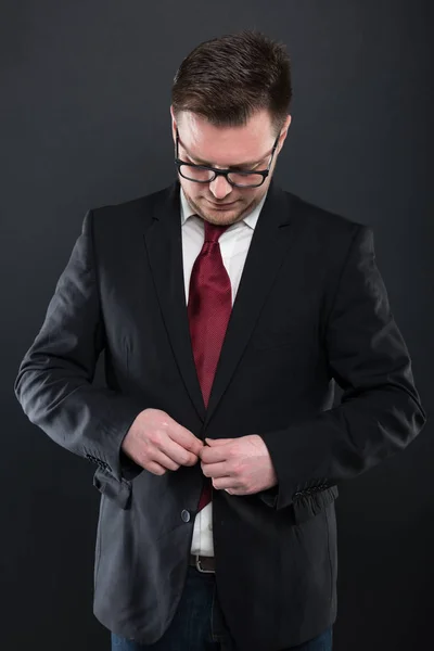 Portrait of business man wearing black suit showing buttoning ja — Stock Photo, Image