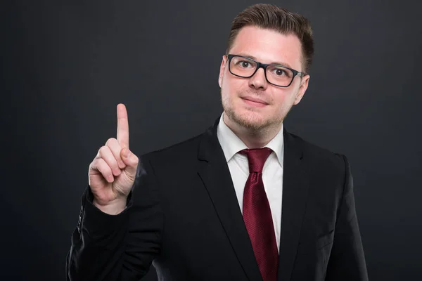 Portrait of business man wearing black suit holding index finger — Stock Photo, Image